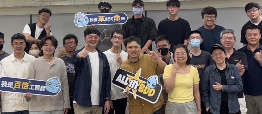 學員合照，手上舉著「我是百倍工程師」「我要革自己的命」「ALL IN BDD」